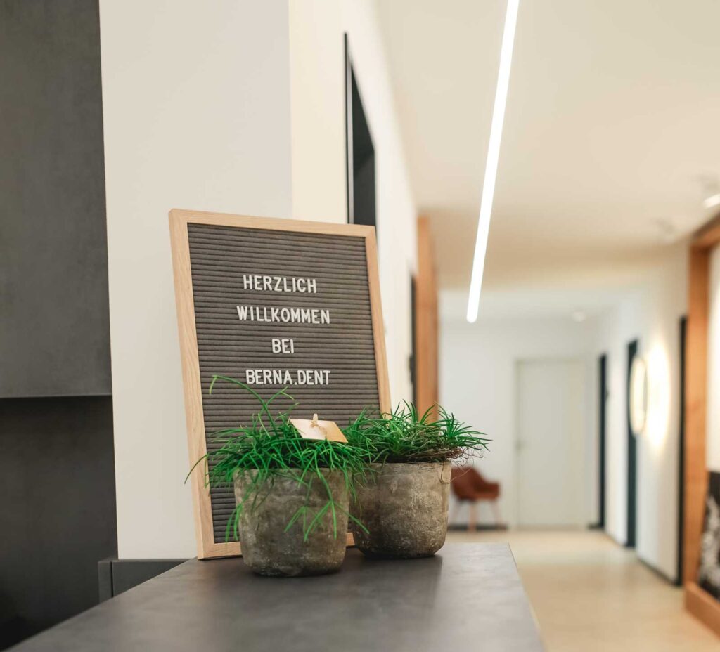 Ein Schild auf dem "Herzlich willkommen bei berna.dent" steht.